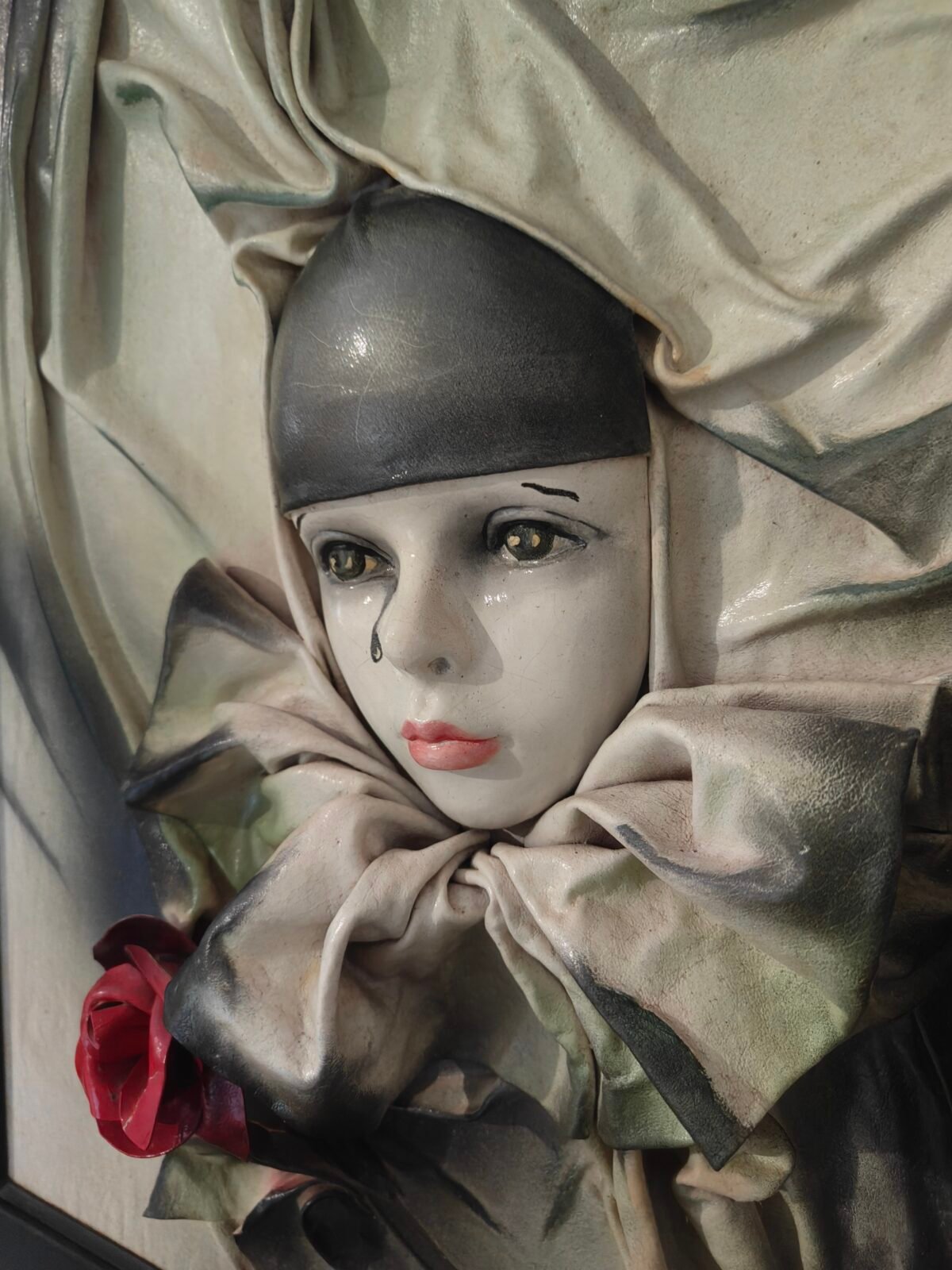 détail visage pierrot cuir sculpté tableau relief