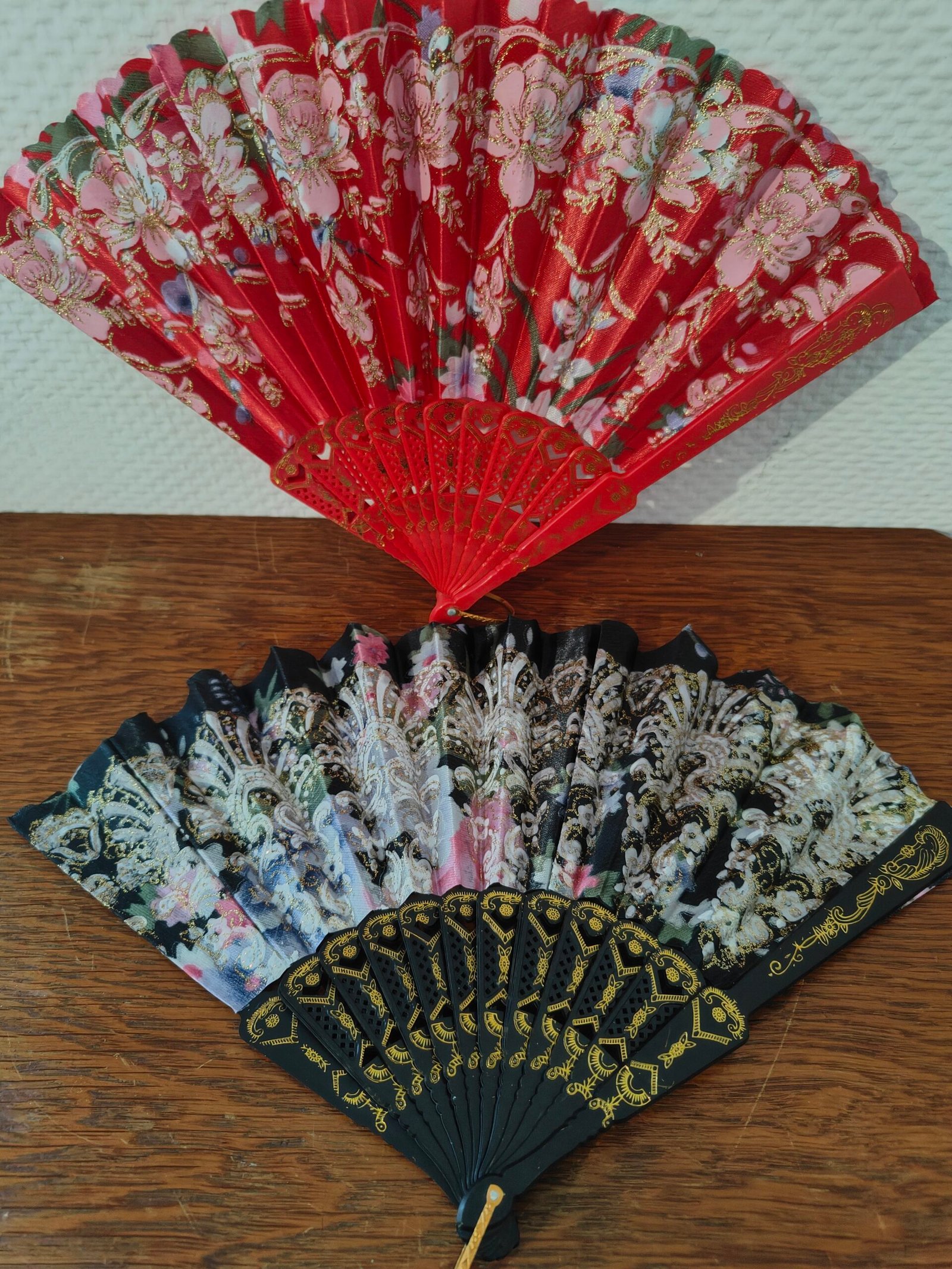 éventail vintage rouge avec motifs floraux et dorures scintillantes