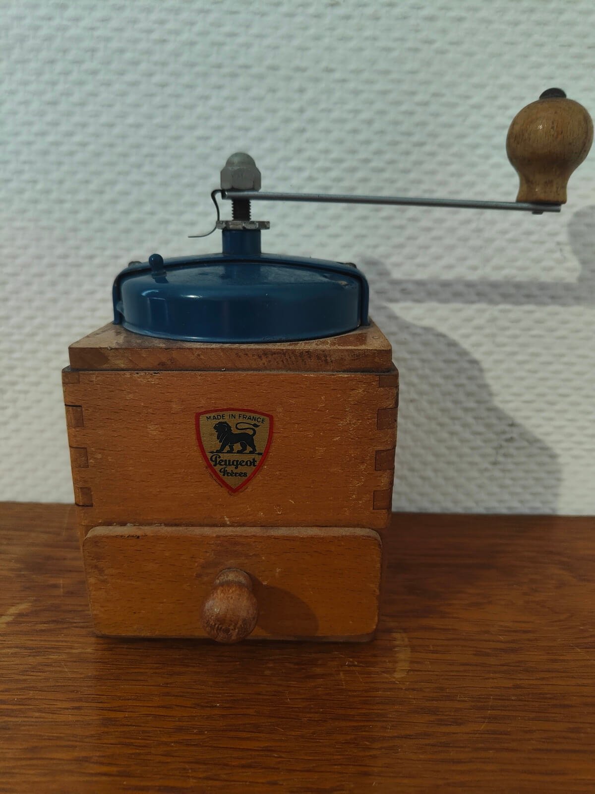 Moulin à café Peugeot Frères ancien en bois vu de face avec écusson d'origine