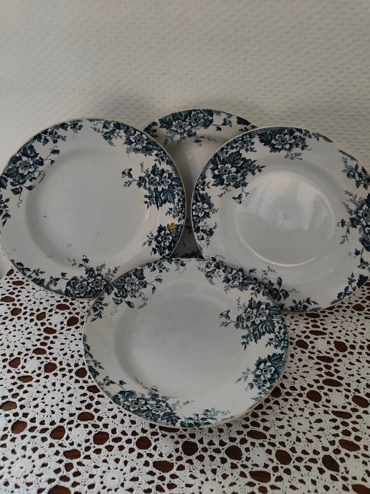 Deux assiettes creuses à décor floral bleu foncé et vert sur fond crème, présentées l'une devant l'autre
